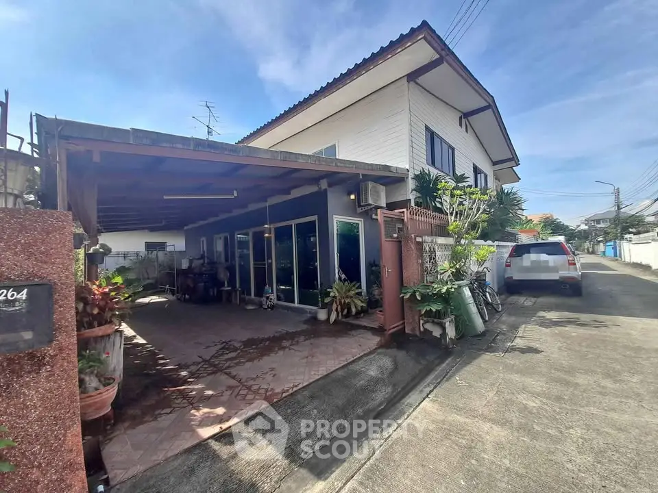 Charming suburban house with carport and lush greenery in a quiet neighborhood.