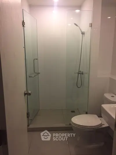 Modern bathroom with glass shower enclosure and sleek fixtures