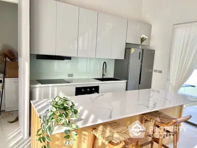 Modern kitchen with sleek white cabinetry and marble island