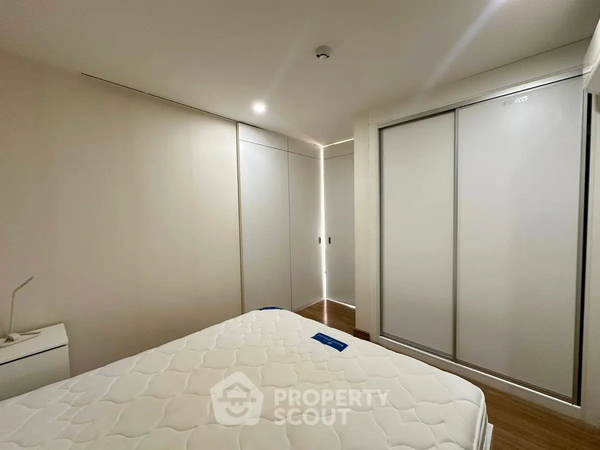 Spacious modern bedroom with sleek sliding wardrobes and cozy lighting