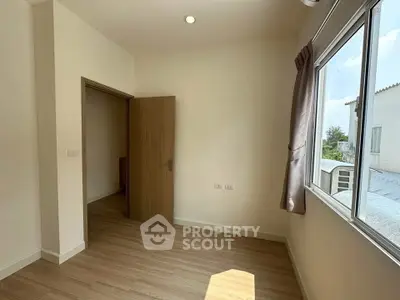 Bright and airy room with wooden flooring and large window offering natural light.