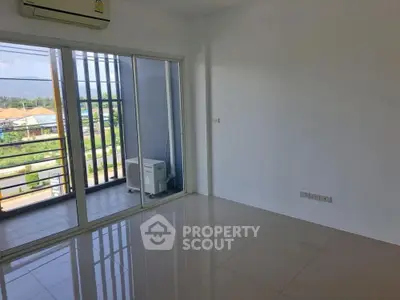 Spacious and sunlit living room with glossy tiled flooring and a large window offering a serene view, perfect for modern living.