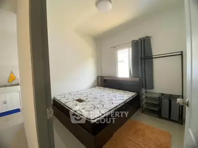 Cozy bedroom with natural light, modern bed, and minimalist decor.