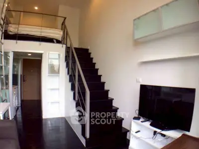 Modern loft apartment with sleek staircase and cozy living area