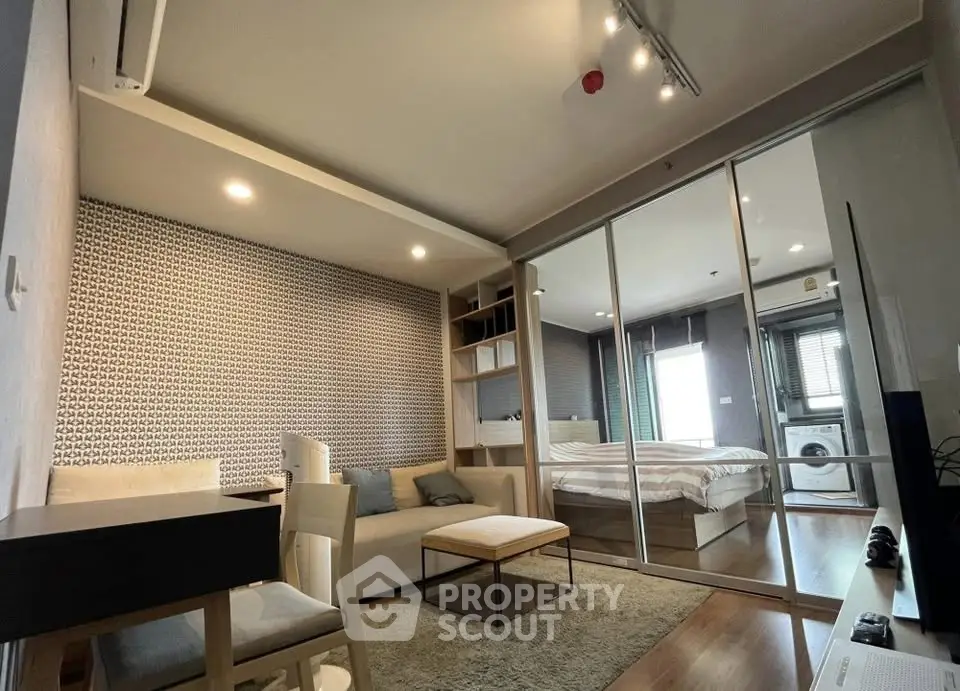 Modern studio apartment with stylish decor and open layout, featuring a cozy living area and bedroom with mirrored closet.