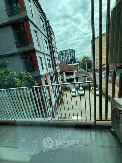 Modern apartment balcony with city view and parking area, ideal for urban living.