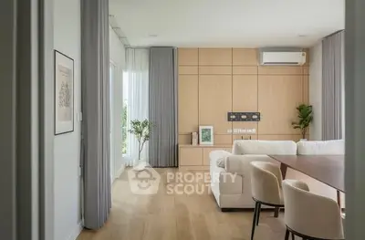 Modern living room with elegant decor, wooden flooring, and natural light