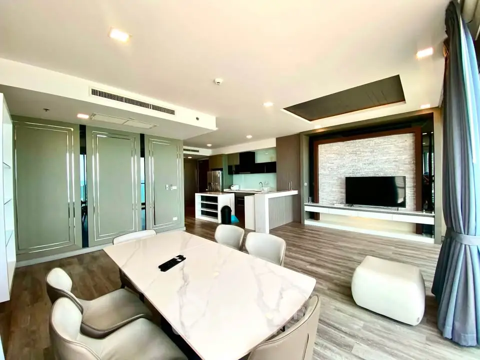 Spacious modern living room with open kitchen and elegant dining area in luxury apartment.