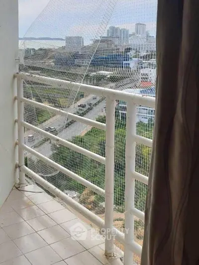 High-rise balcony with safety netting and cityscape view, ideal for urban living.