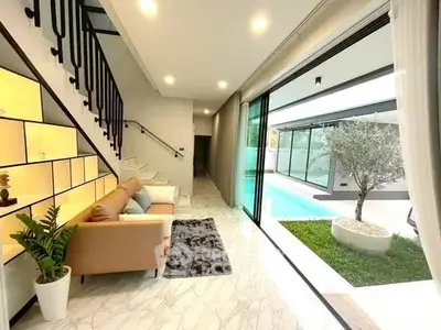 Modern living room with pool view and stylish staircase in luxury home