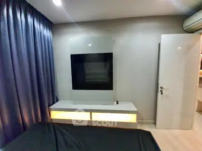 Modern bedroom with sleek TV unit and ambient lighting