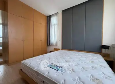 Spacious bedroom with large wardrobe and natural light, perfect for comfortable living.
