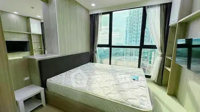 Modern bedroom with large windows offering stunning city views in a high-rise apartment.