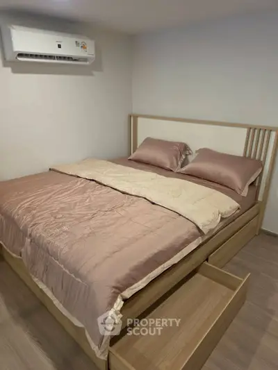 Cozy bedroom with modern air conditioning and stylish wooden bed frame, perfect for restful nights.