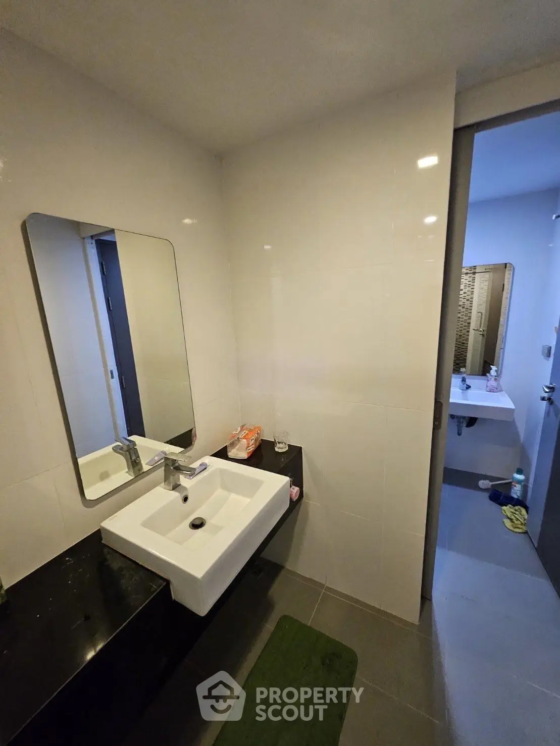 Modern bathroom with sleek sink and mirror, featuring contemporary design and clean lines.