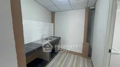 Compact kitchen with sleek black countertops and white subway tile backsplash
