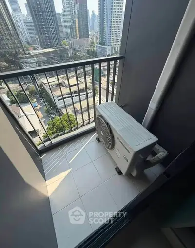 Compact balcony with city view and air conditioning unit in modern high-rise apartment.