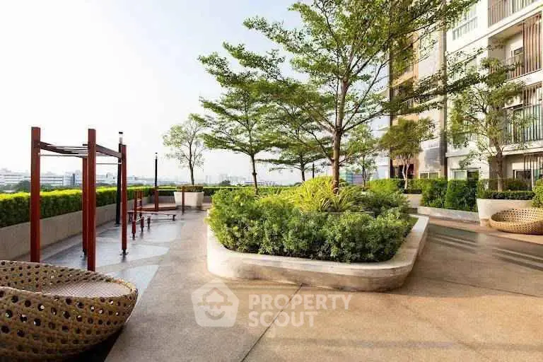 Luxurious rooftop garden with modern seating and lush greenery in a high-rise building.