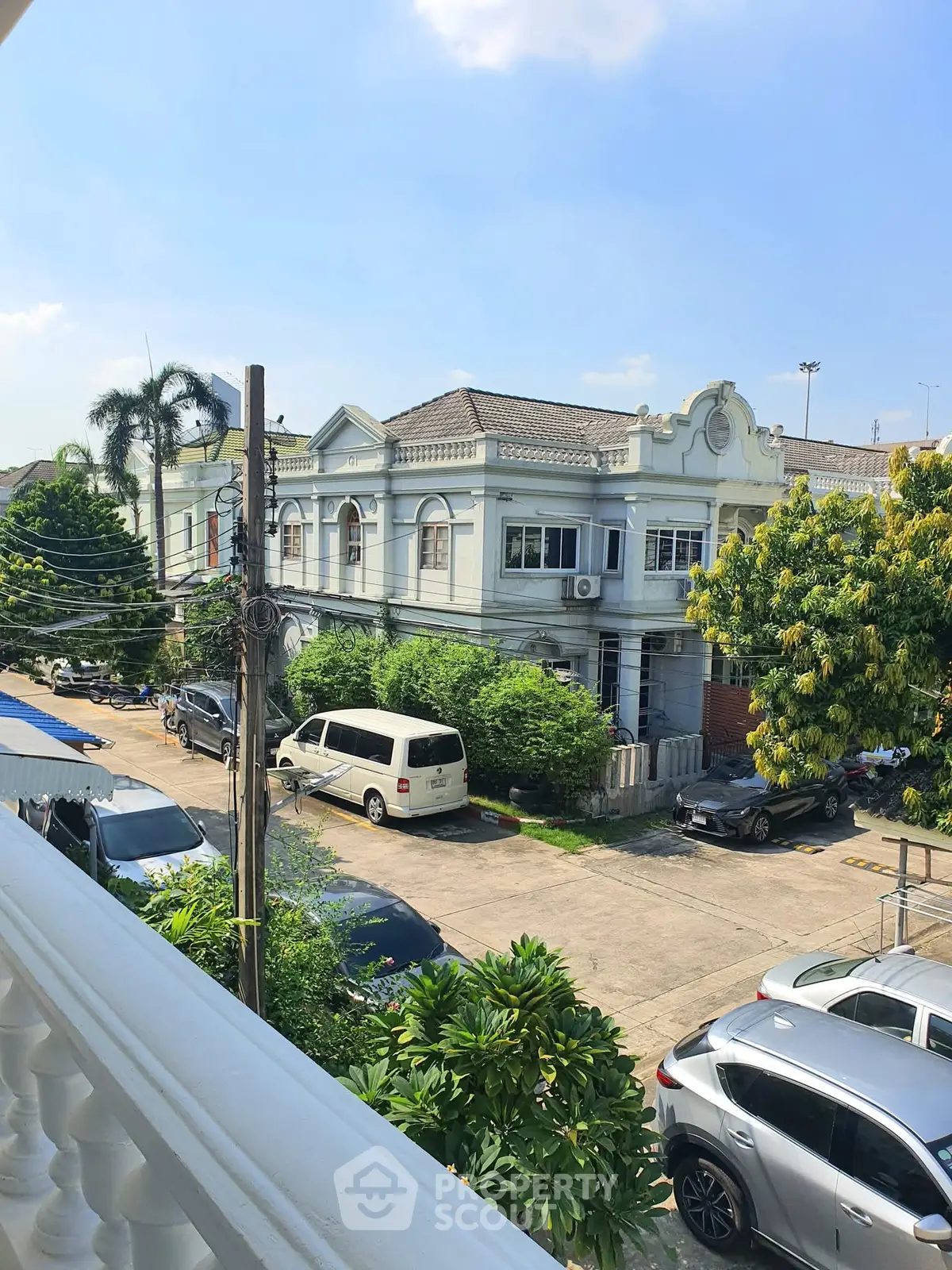 Charming residential street view with classic architecture and lush greenery.