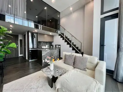 Luxurious modern living room with high ceilings and elegant staircase in a stylish apartment.