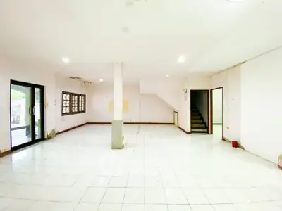 Spacious open-plan living area with tiled flooring and large windows for natural light.