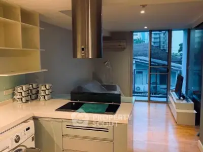 Modern kitchen with sleek design and open layout, featuring a washing machine and large windows with a view.