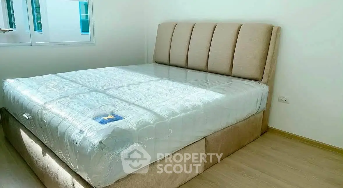 Spacious bedroom with a large bed and natural light from the window, perfect for relaxation.