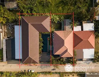 Aerial view of a spacious property with tiled roofs and lush greenery.