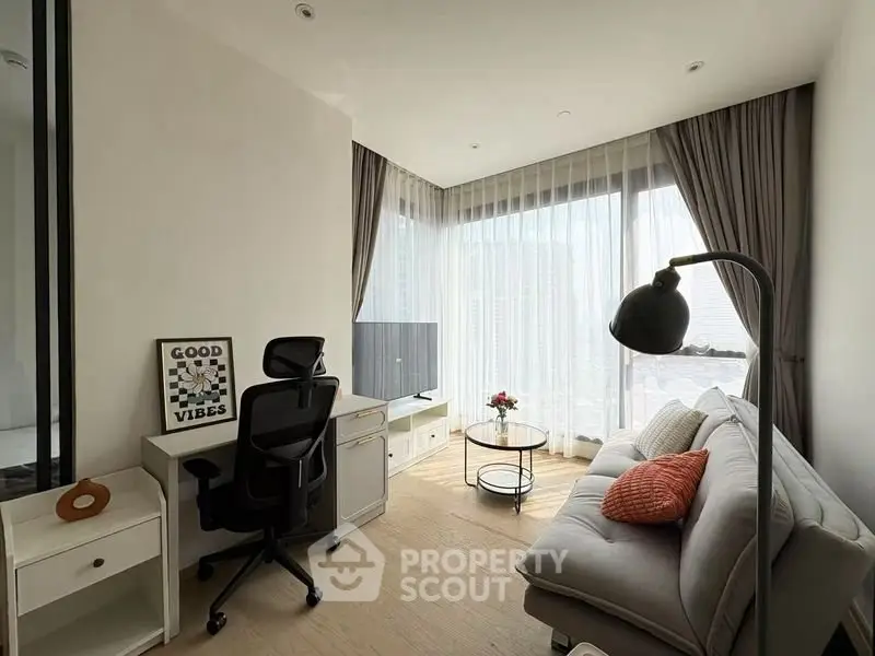 Modern living room with stylish decor, cozy sofa, and natural light from large windows.
