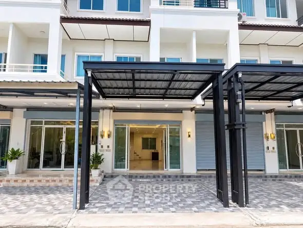 Modern townhouse exterior with covered parking and large glass doors.