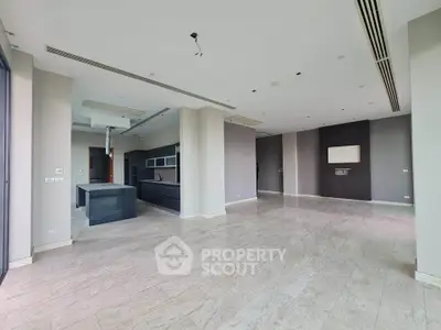 Spacious open-plan living area with modern kitchen and elegant flooring