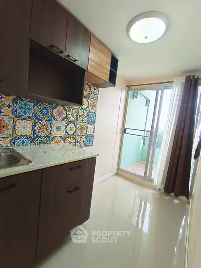 Charming kitchen with colorful backsplash and balcony access in modern apartment