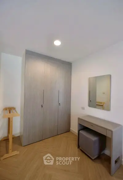 Modern bedroom with sleek wardrobe and stylish vanity in a cozy apartment.