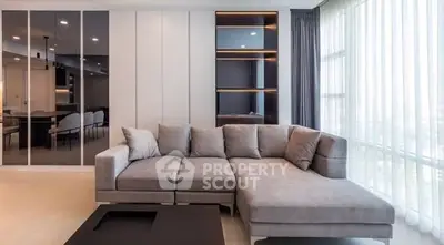 Modern living room with stylish gray sectional sofa and large windows