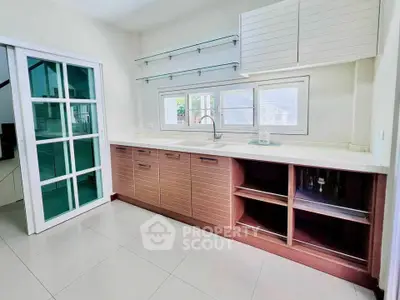 Modern kitchen with sleek cabinetry and large windows for natural light.