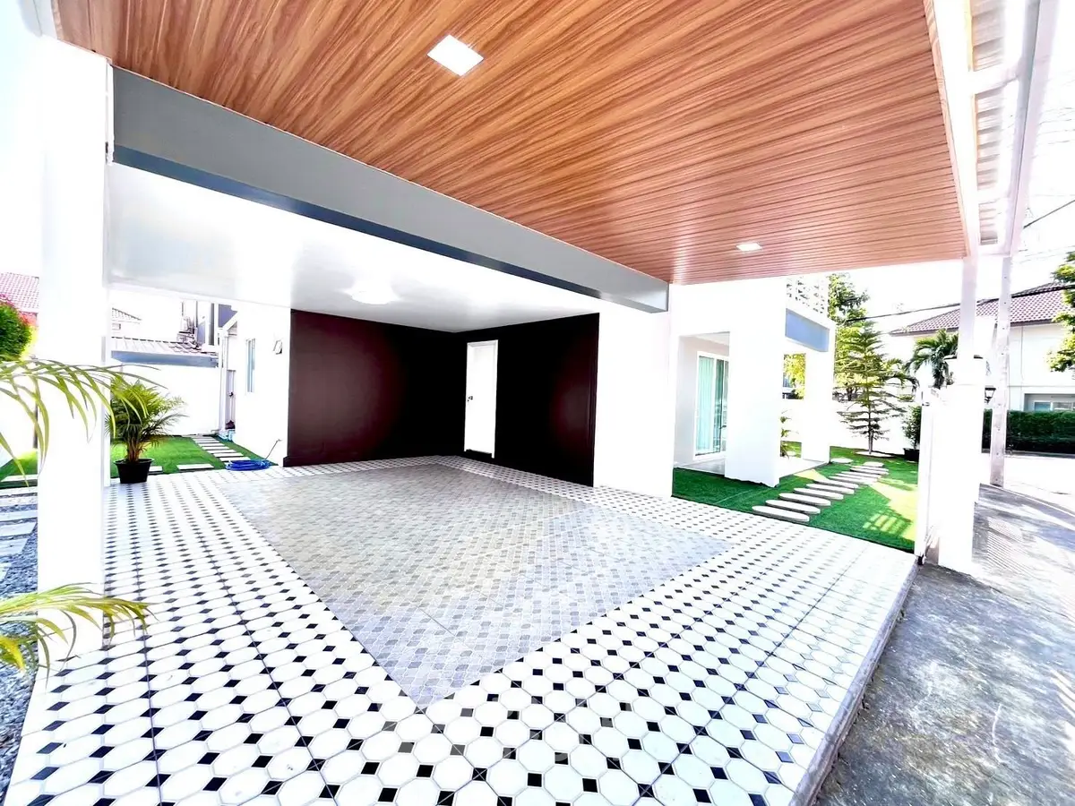 Modern carport with stylish tile flooring and wooden ceiling in a contemporary home exterior.