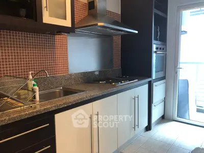 Modern kitchen with sleek cabinetry, granite countertops, and stainless steel appliances, featuring a closed layout.