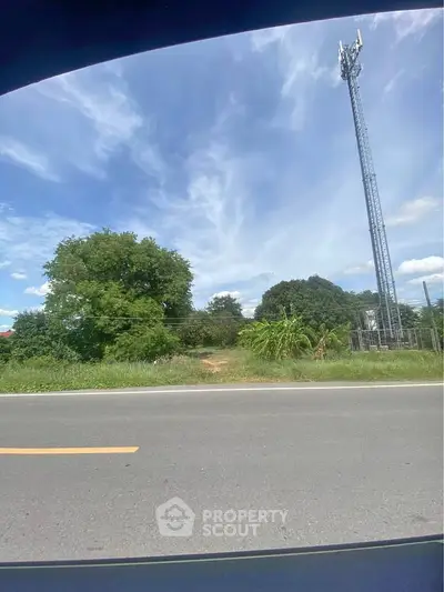 Vacant land with clear sky and cell tower, ideal for development opportunities.