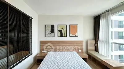 Modern bedroom with stylish decor and large window view in urban apartment.