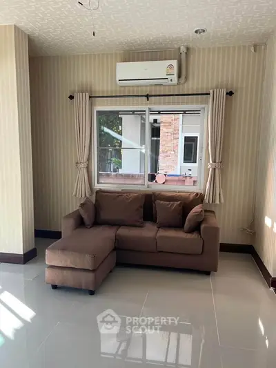 Cozy living room with stylish sofa and air conditioning, perfect for relaxation.