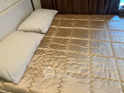 Luxurious bedroom with elegant bedding and plush pillows in a modern real estate property.