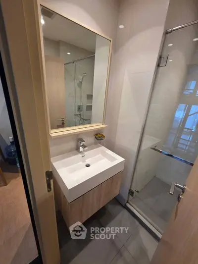 Modern bathroom with sleek vanity and glass shower enclosure