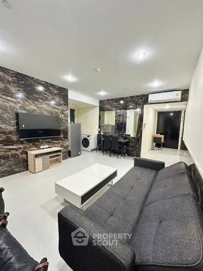 Modern living room with sleek furniture and marble accent wall