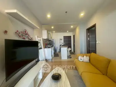 Modern living room with yellow sofa and open kitchen layout in stylish apartment.