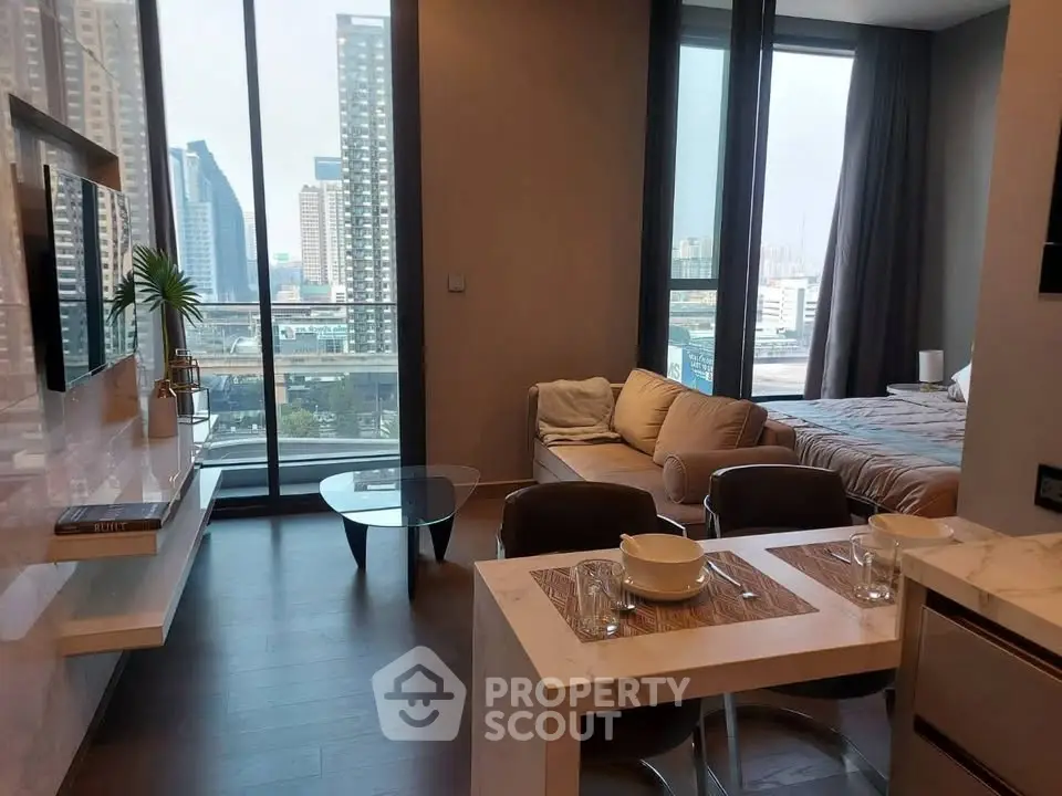 Modern open-plan living room with city view, featuring sleek furniture and large windows.
