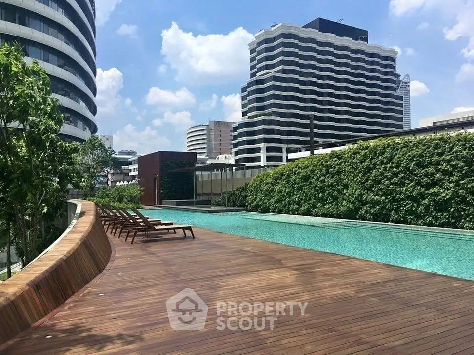Luxurious rooftop pool with city skyline views and sun loungers, perfect for relaxation and leisure.