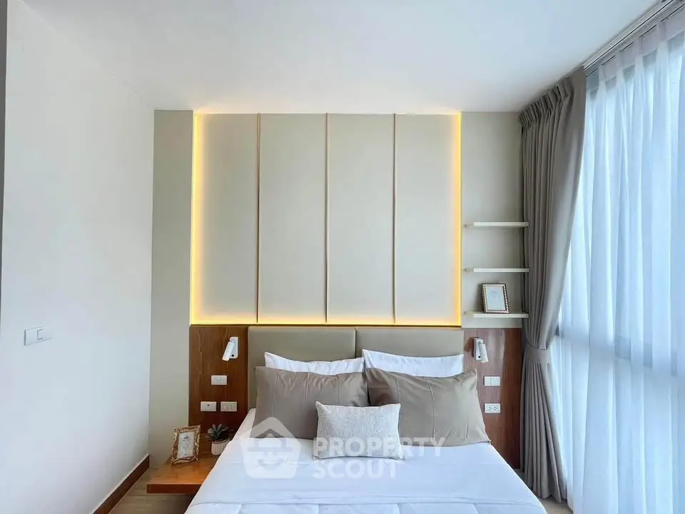 Modern bedroom with stylish lighting and large window for natural light.