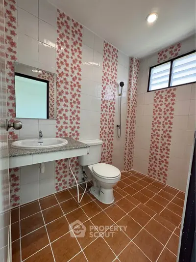 Charming bathroom with floral tile accents and modern fixtures, perfect for a cozy home.