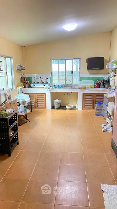 Spacious kitchen with ample storage and natural light, featuring a closed layout and modern appliances.