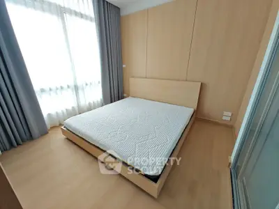 Modern minimalist bedroom with wooden flooring and large windows